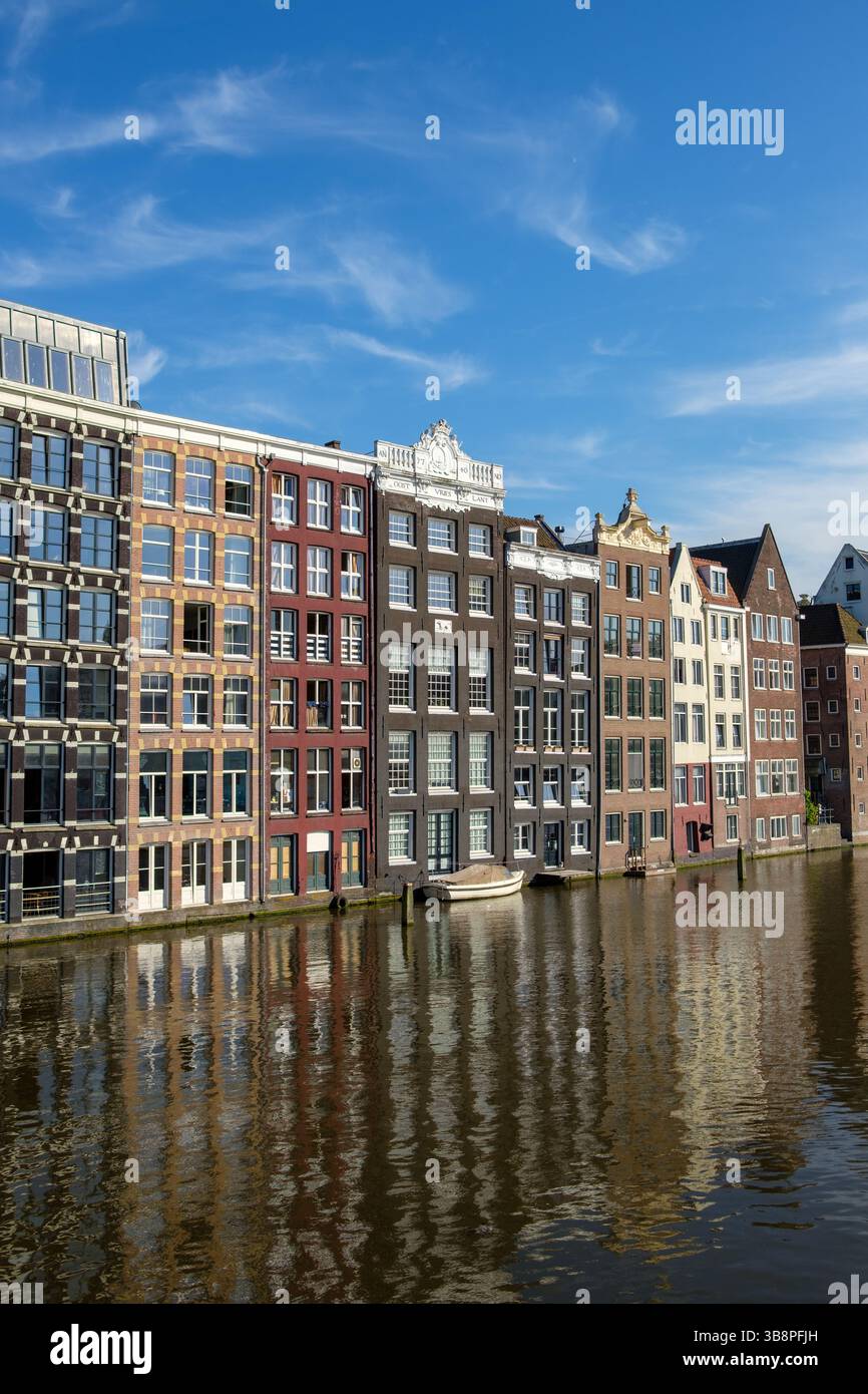 Les maisons de canal d'Amsterdam se reflètent dans l'eau. Les touristes visitent pour voir l'architecture historique. Banque D'Images