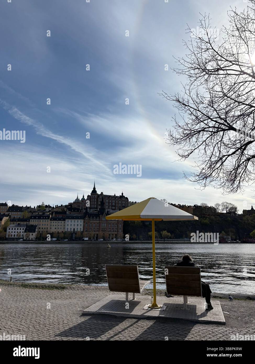 Moment solitaire au bord de l'eau à Stockholm avec vue sur l'architecture panoramique - Image de stock capturée avec un smartphone