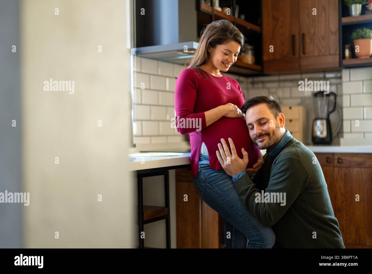 Belle femme enceinte et son beau mari sourient tout en passant du temps ensemble. Un couple heureux qui a hâte de devenir parents Banque D'Images