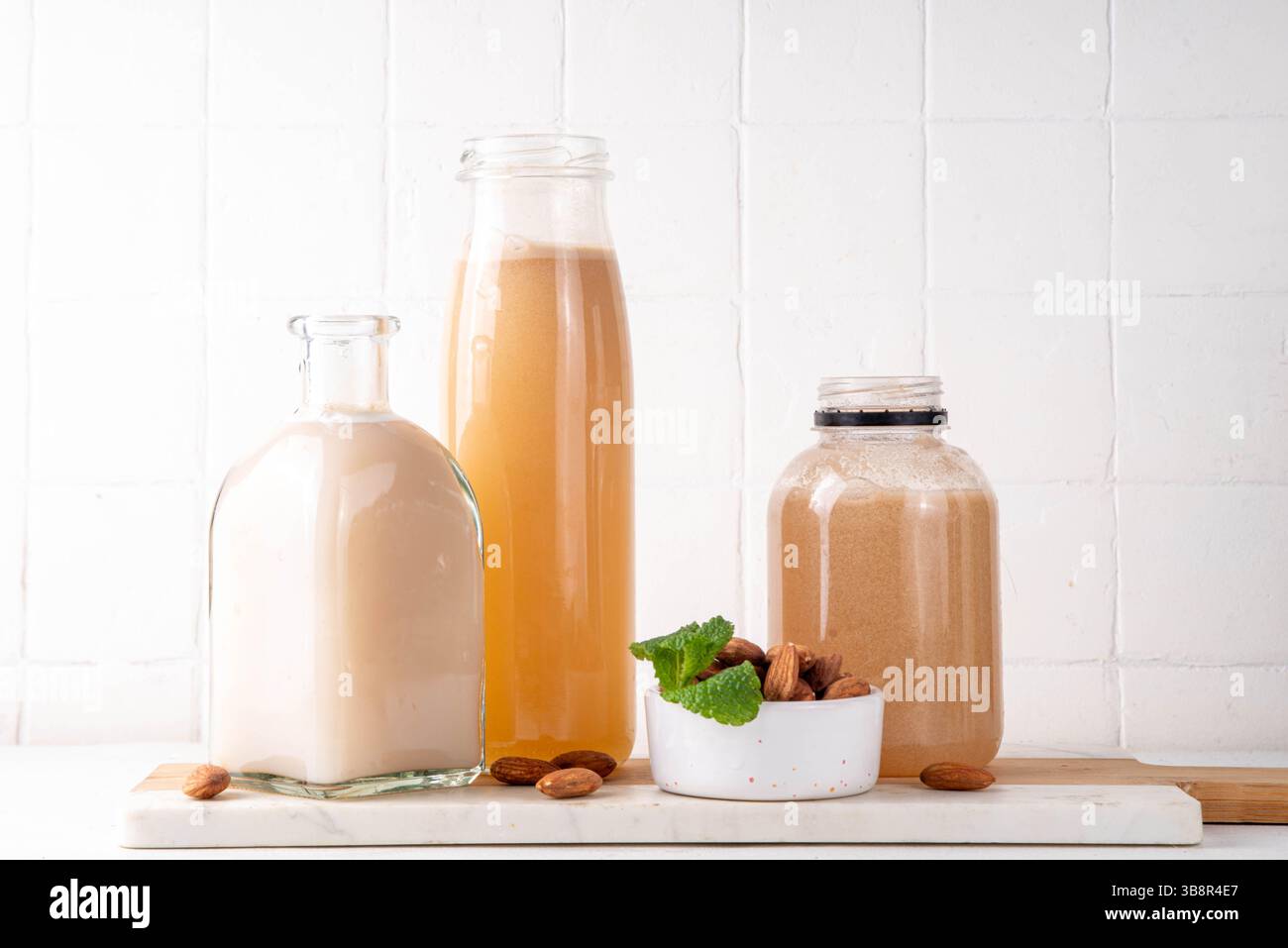 Sirop d'orgeat d'amande maison dans différentes bouteilles, amandes, eau, sucre et sirop d'eau de fleur d'oranger pour faire des cocktails sucrés Banque D'Images