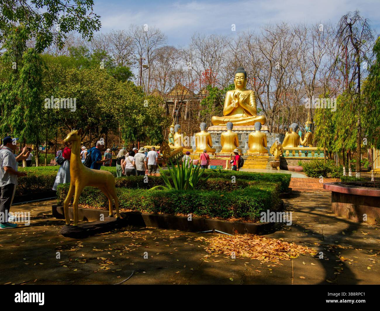 Les visiteurs observent une scène statuaire de Bouddha enseignant ses disciples dans les jardins de la pagode de Phnom Bros Banque D'Images Les visiteurs observent une scène statuaire de Bouddha enseignant ses disciples dans les jardins de la pagode de Phnom Bros Banque D'Images