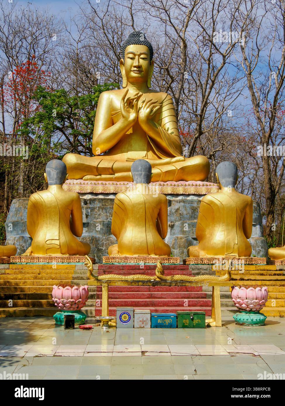Les visiteurs observent une scène statuaire de Bouddha enseignant ses disciples dans les jardins de la pagode de Phnom Bros Banque D'Images Les visiteurs observent une scène statuaire de Bouddha enseignant ses disciples dans les jardins de la pagode de Phnom Bros Banque D'Images