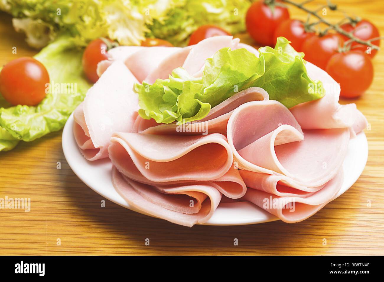 Tranches de jambon frais avec lattuce et tomate cerise sur la plaque Banque D'Images Tranches de jambon frais avec lattuce et tomate cerise sur la plaque Banque D'Images