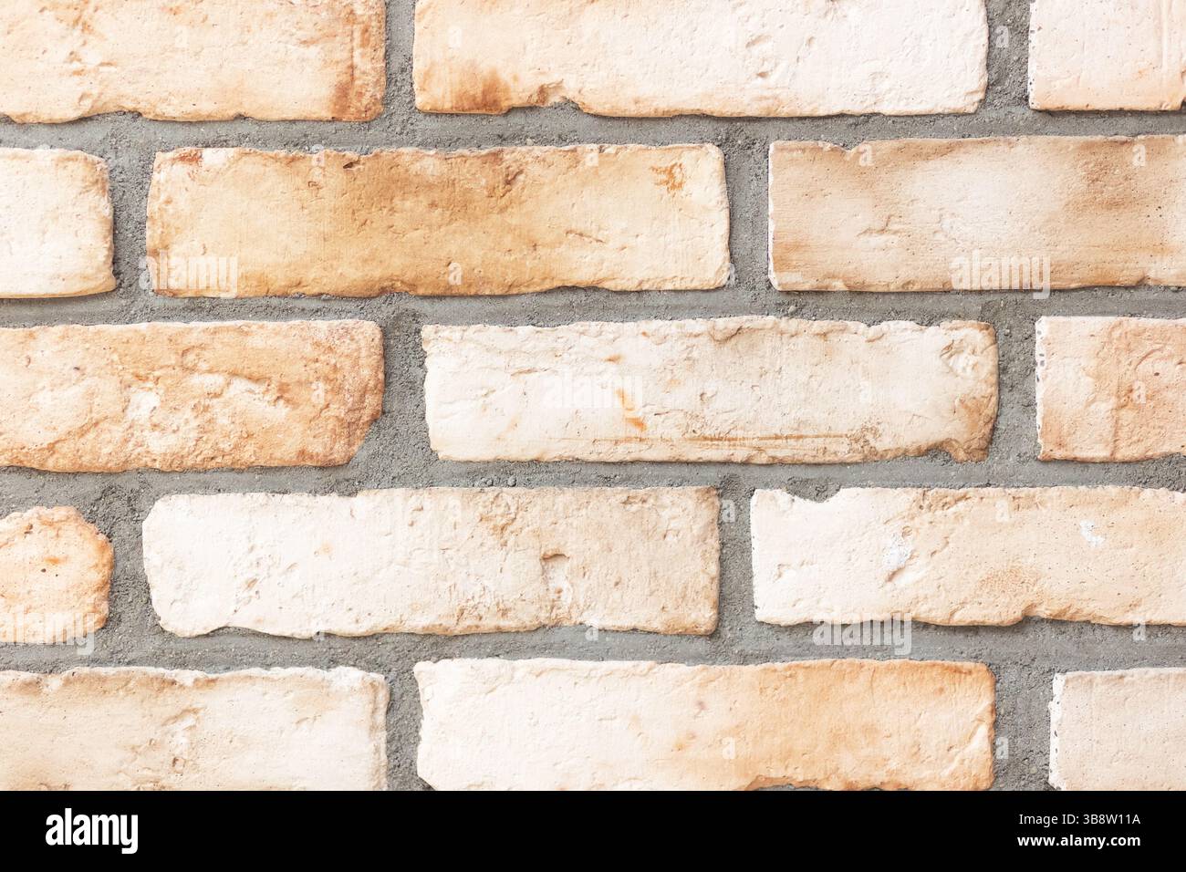 Mur rustique de briques légères. Fond de maçonnerie texturé. Tons beige et blanc. Elément de construction classique. Surface rugueuse pour la conception. Banque D'Images