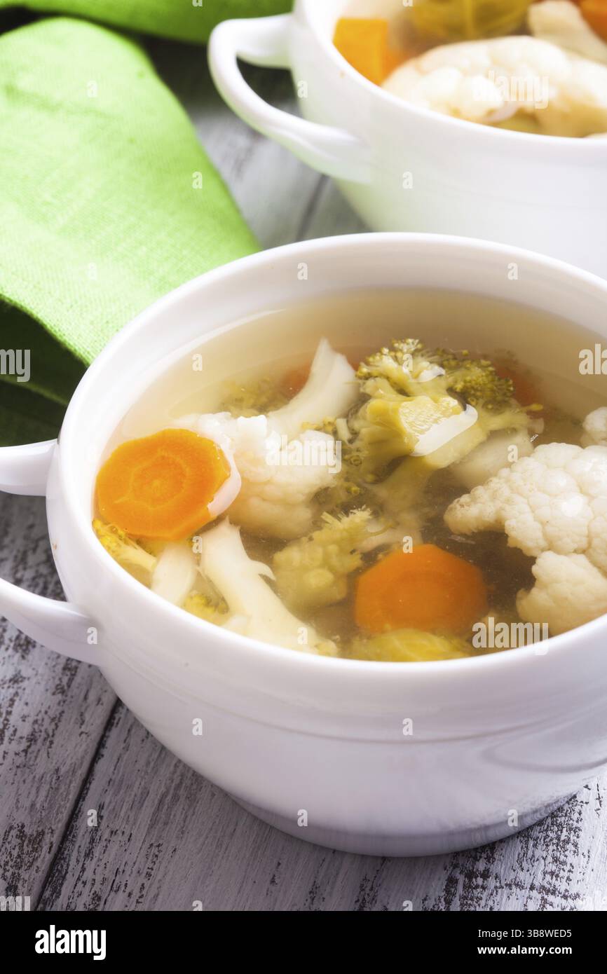 Soupe de légumes dans le bol blanc sur la table fermer Banque D'Images