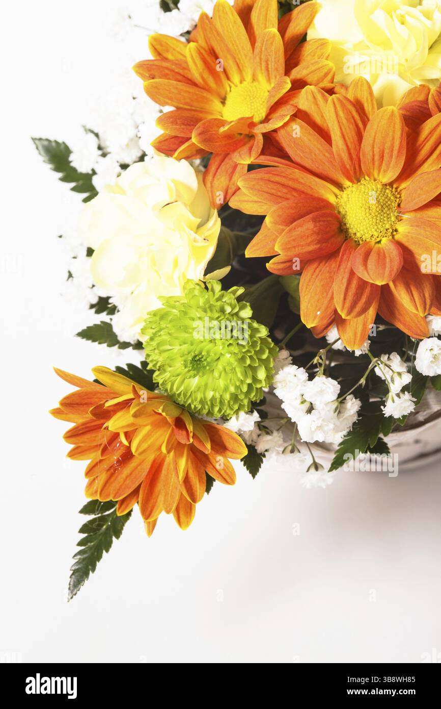 Magnifique bouquet de fleurs brillantes dans un panier blanc sur nappe blanche Banque D'Images