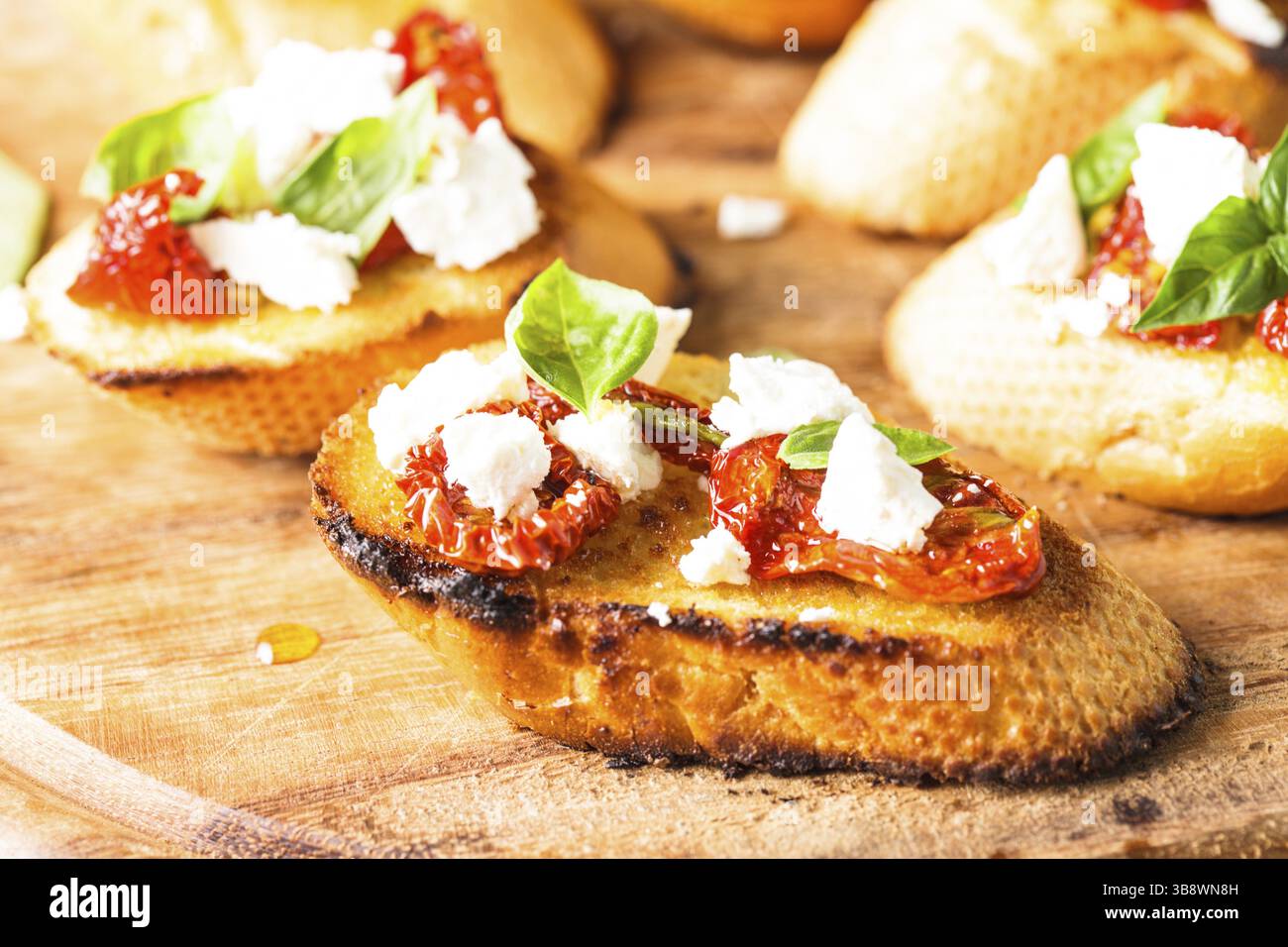Bruschetta à l'huile d'olive, tomates séchées, feta et basilic frais Banque D'Images Bruschetta à l'huile d'olive, tomates séchées, feta et basilic frais Banque D'Images