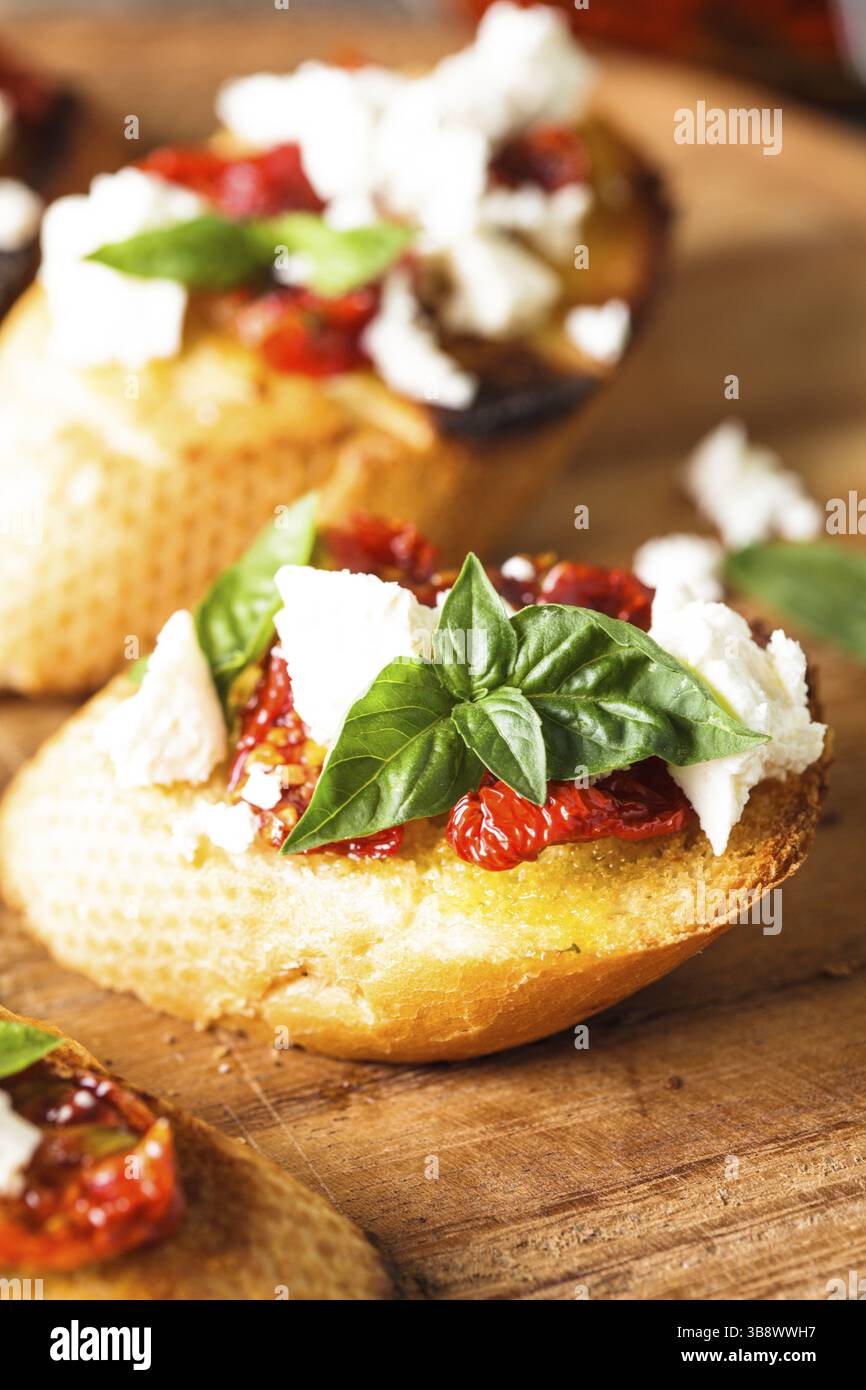Bruschetta à l'huile d'olive, tomates séchées, feta et basilic frais Banque D'Images Bruschetta à l'huile d'olive, tomates séchées, feta et basilic frais Banque D'Images