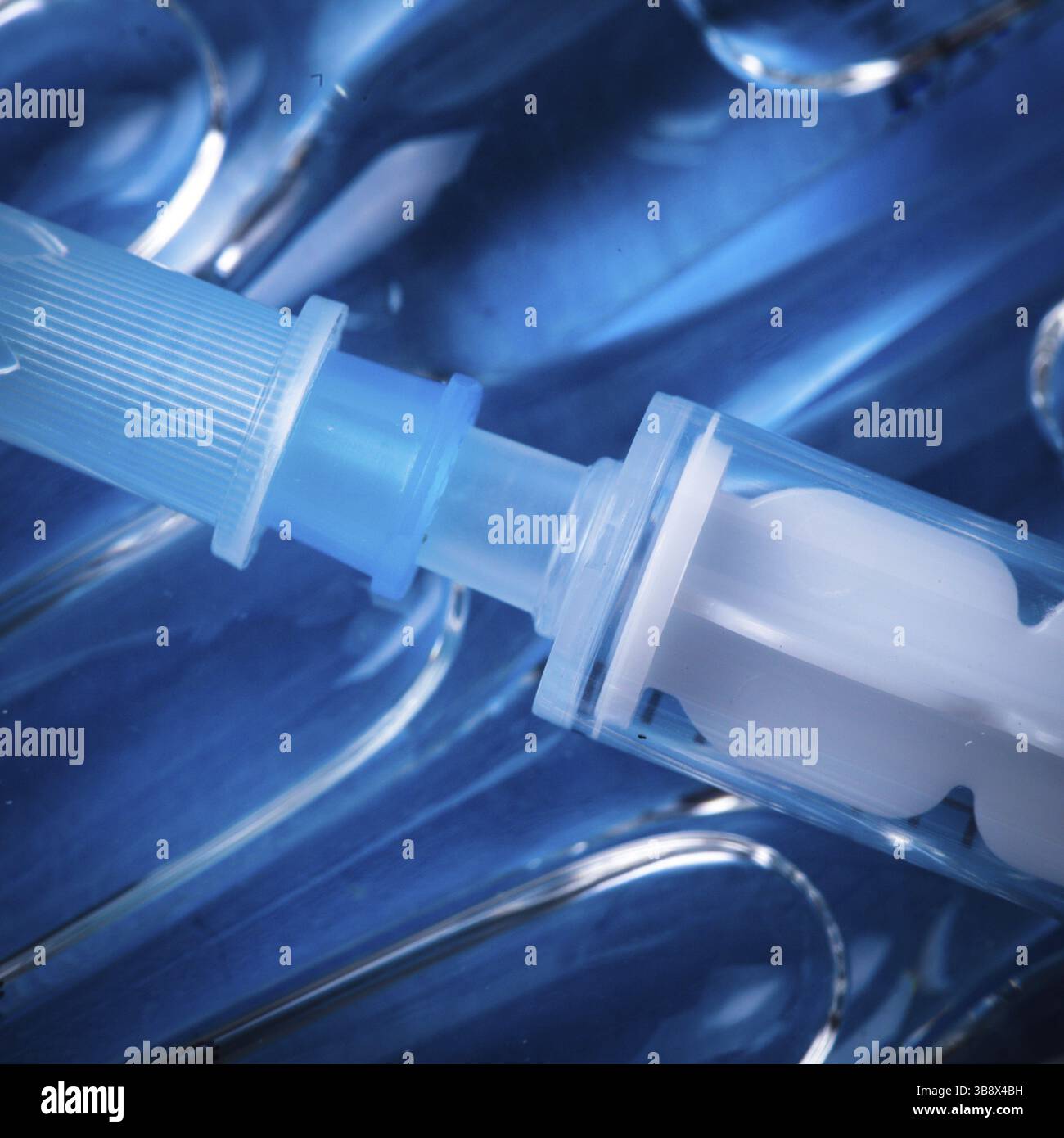 Gros plan sur l'injection du vaccin avec fond bleu Banque D'Images