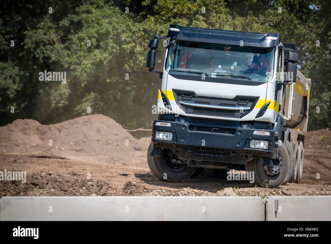Chargeuse sur pneus transportant du gravier et de la terre sur un chantier de construction d'autoroute Banque D'Images