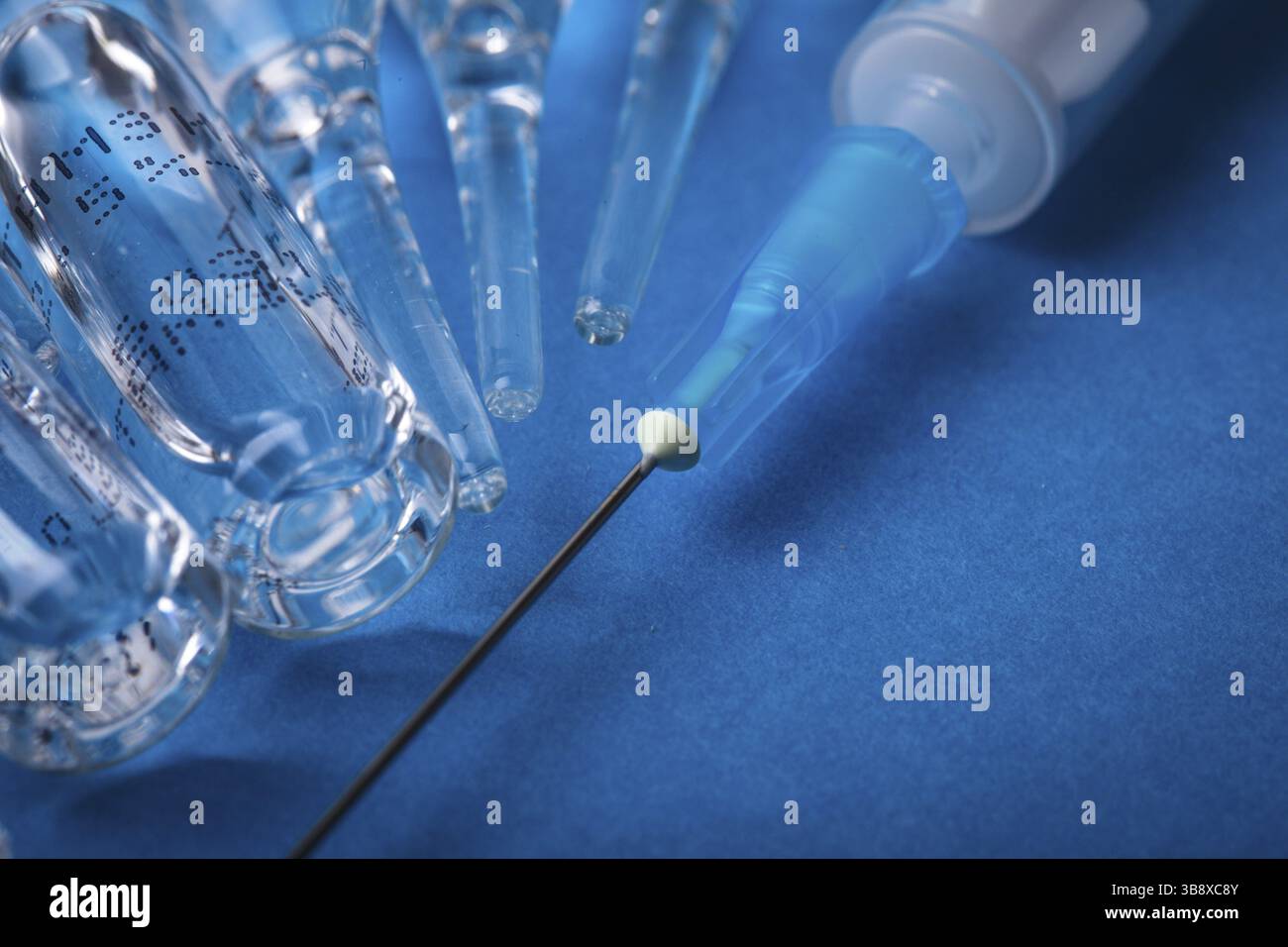 Gros plan sur l'injection du vaccin avec fond bleu Banque D'Images