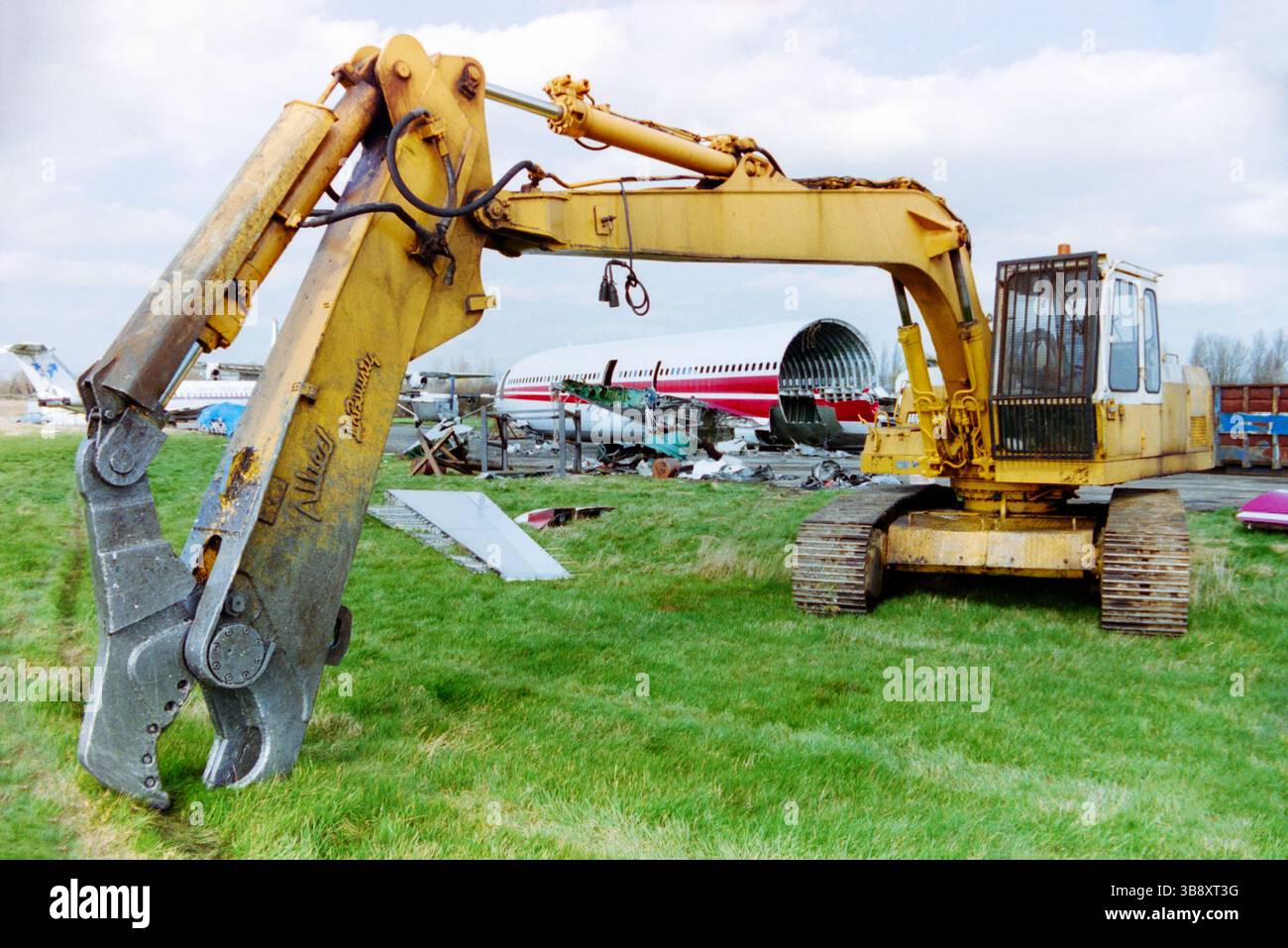 Allied laBounty cisailles machines utilisées pour mettre au rebut les avions retirés de la retraite à l'aéroport de Southend, Essex, Royaume-Uni en 1999. Vestiges visibles de l'avion de ligne El-col Lockheed l-1011 TriStar 1, l'un des plus gros avions à atterrir à l'aéroport de Southend. Le Tristar a été livré neuf à TWA en 1973 et a servi avec la compagnie aérienne sous le nom de N31014 jusqu'en 1997, avant de rejoindre TBG Airways et Aer Turas, bien que le fuselage soit resté dans ses couleurs TWA jusqu'à la fin. Il débarque à Southend en août 1998 et sa démolition est terminée en mars 1999. Banque D'Images