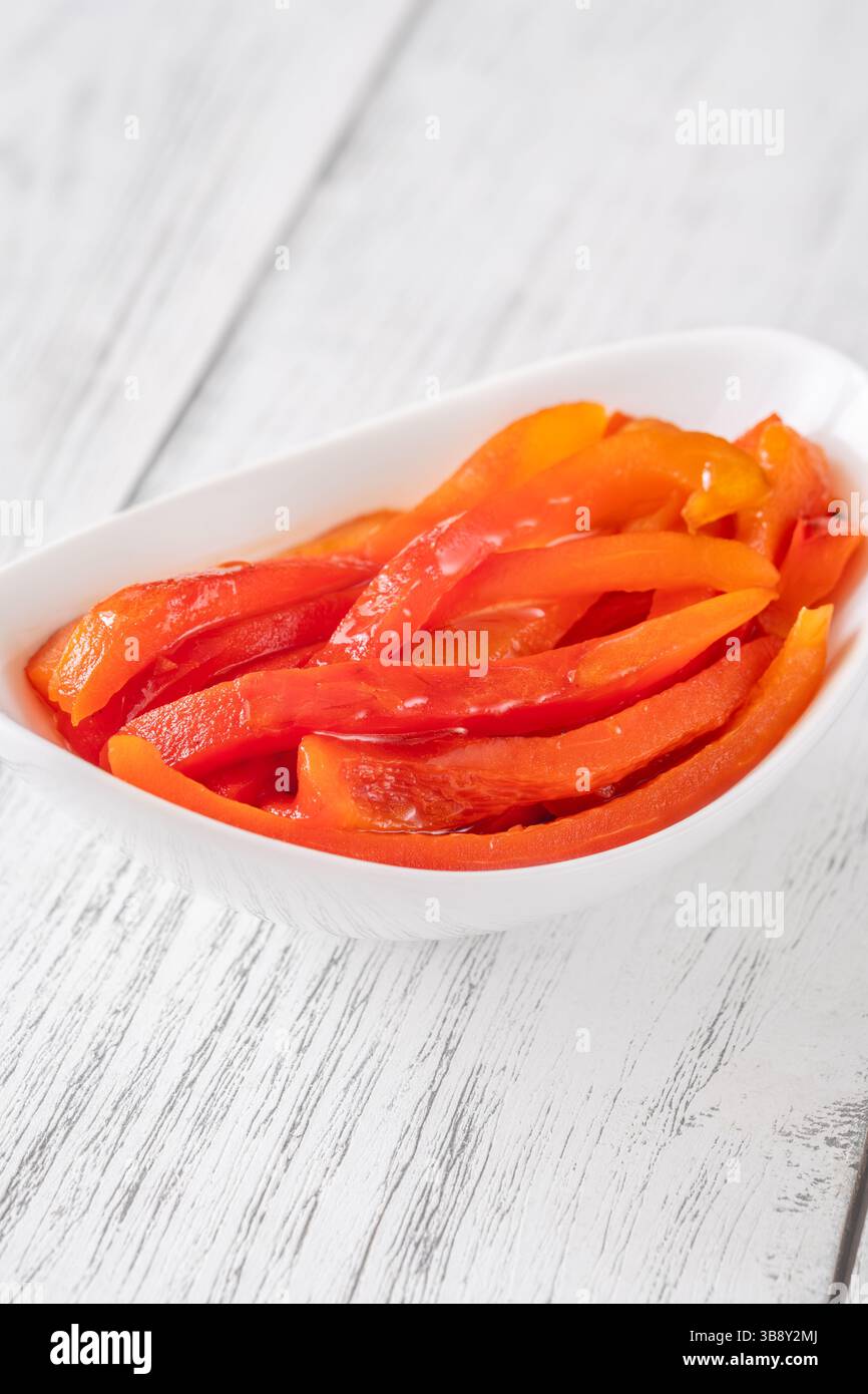 Lanières de poivrons rouges carbonisés disposées dans un bol, saveur fumée et sucrée Banque D'Images