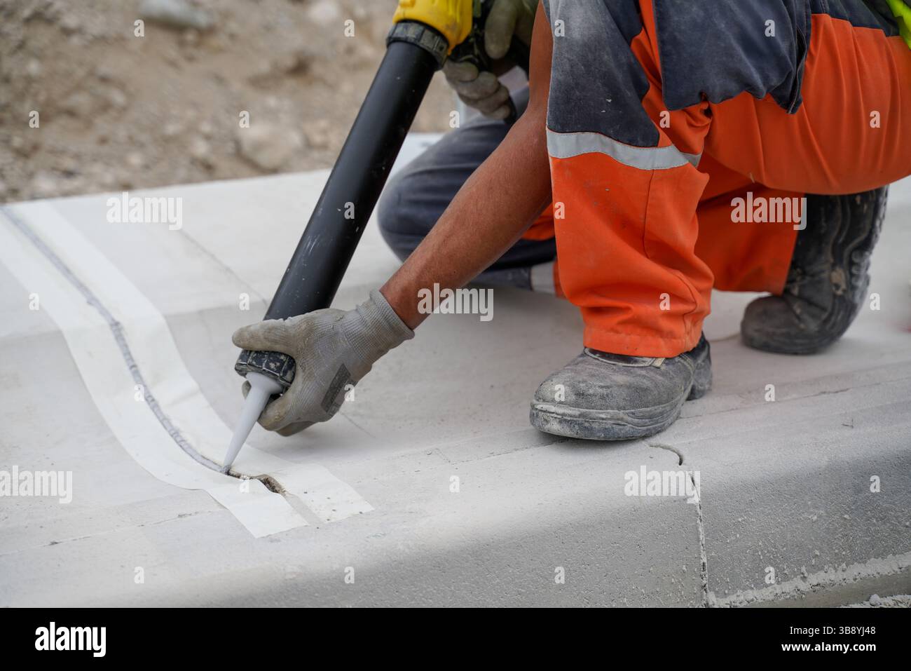Gros plan de l'écart de remplissage entre les bordures de béton sur le chantier de construction d'autoroute pour assurer une étanchéité durable, empêcher l'accumulation d'eau, geler le barrage Banque D'Images