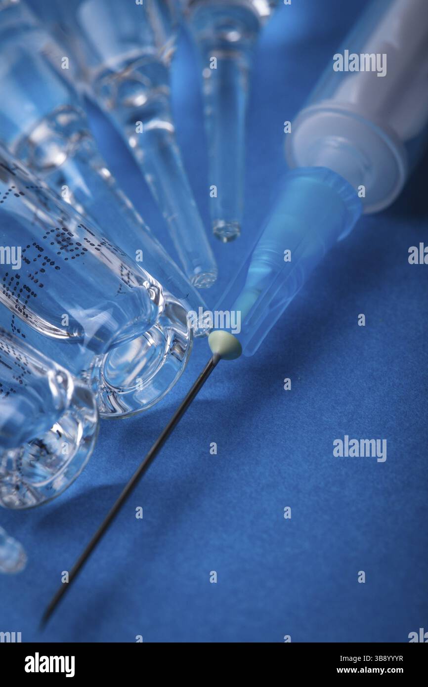 Gros plan sur l'injection du vaccin avec fond bleu Banque D'Images