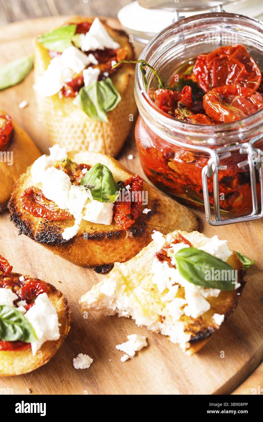 Bruschetta à l'huile d'olive, tomates séchées, feta et basilic frais Banque D'Images Bruschetta à l'huile d'olive, tomates séchées, feta et basilic frais Banque D'Images