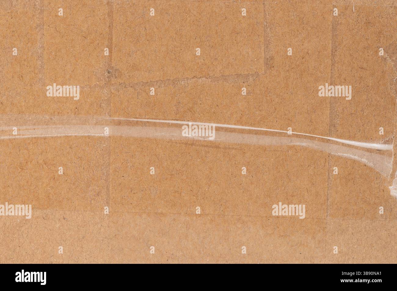 La surface en carton comporte du ruban adhésif transparent utilisé pour sécuriser l'emballage, indiquant la préparation pour l'expédition. Banque D'Images