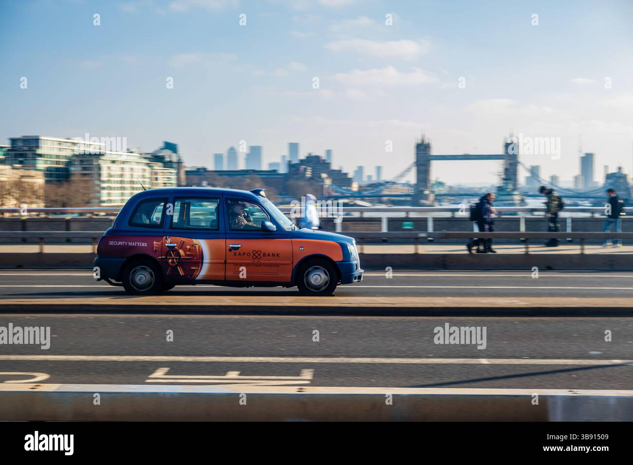 Londres, 14 février 2025 : un taxi traverse le London Bridge, Tower Bridge en arrière-plan. Banque D'Images