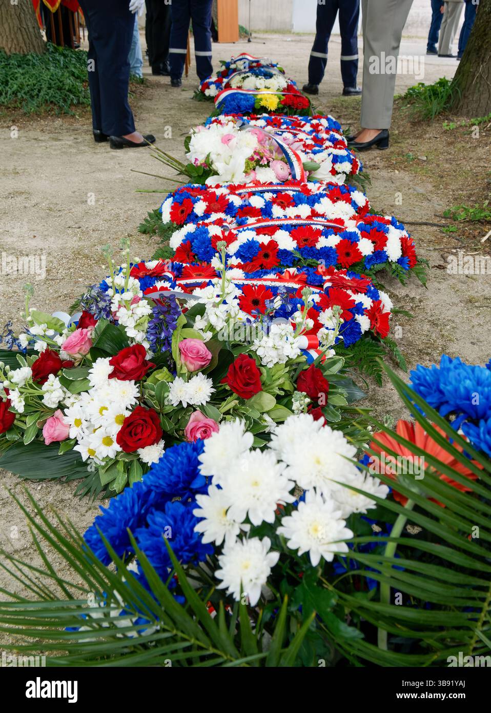 Couronnes de fleurs bleues, blanches et rouges posées pour une cérémonie commémorative, symbolisant les couleurs nationales françaises et un hommage commémoratif. Banque D'Images