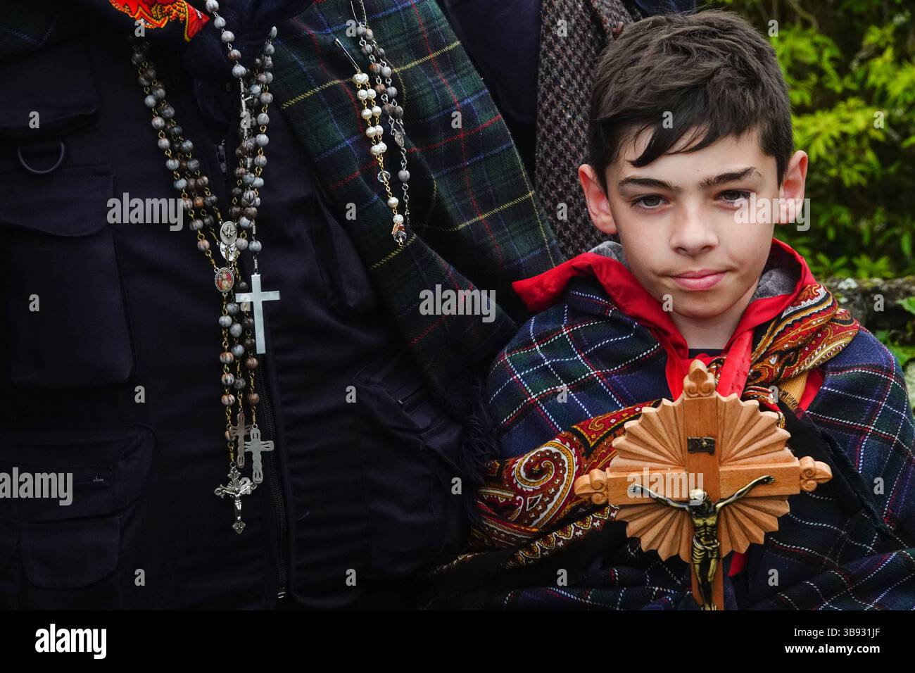 25 mars 2023, Calhetas, Açores, Portugal : un jeune garçon avec un groupe de pèlerins catholiques connus sous le nom de Romeiros, alors qu'ils se reposent au bord de la route pendant leur promenade de 8 jours autour de l'île des Açores de Sao Miguel, le 25 mars 2023 à Calhetas, Portugal. Les pèlerins visitent 100 sanctuaires et églises lors de l’événement datant de 1522, lorsqu’un tremblement de terre a détruit les premières colonies. (Crédit image : © Richard Ellis/ZUMA Press Wire) Banque D'Images