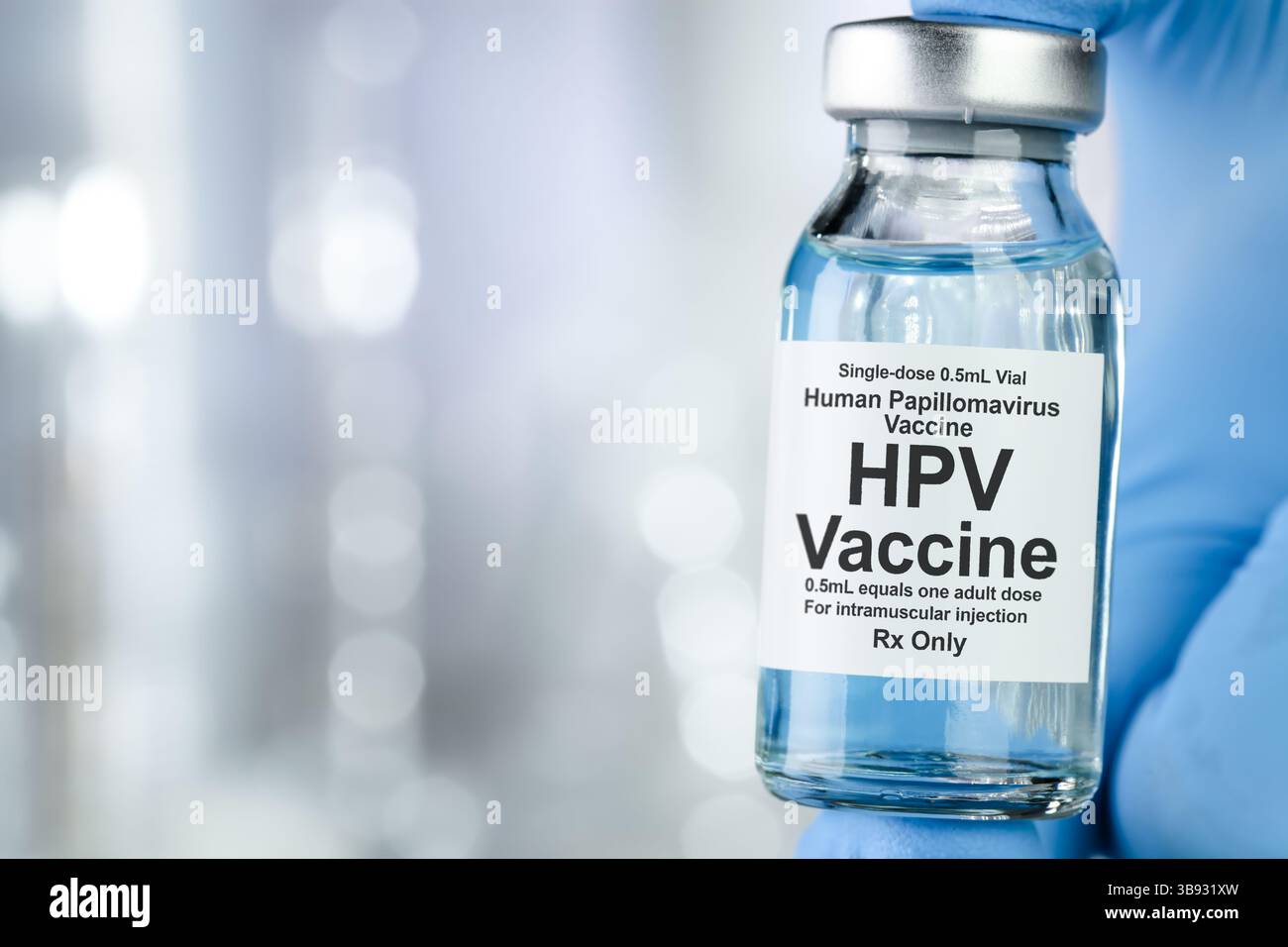 Concept de soins avec une main en bleu gants médicaux holding, HPV Virus du papillome humain, vaccin flacon Banque D'Images