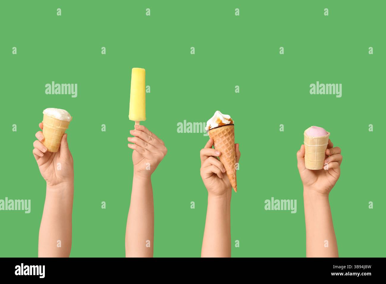 Mains féminines avec différentes glaces sucrées sur fond vert Banque D'Images