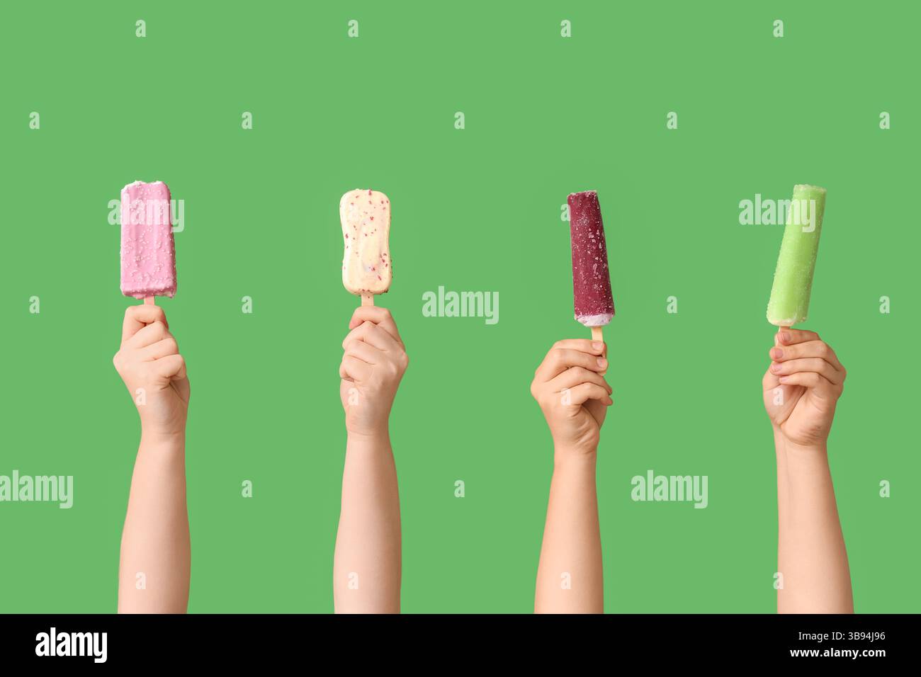 Mains féminines avec différentes glaces sucrées sur fond vert Banque D'Images