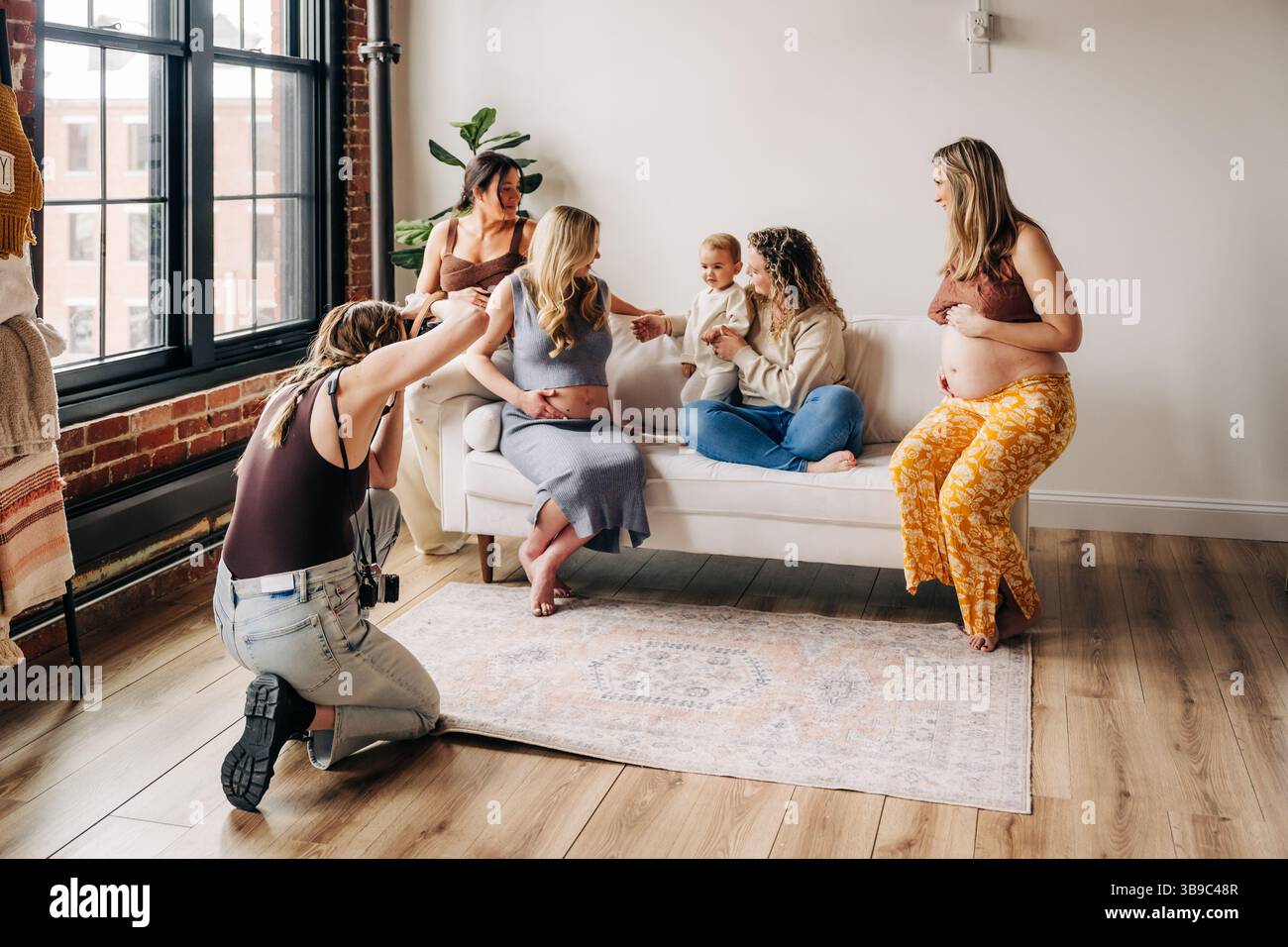 Photographe capture le moment franc d'amis enceintes avec bébé Banque D'Images