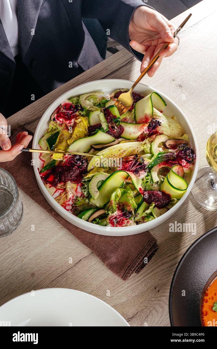 fille mangeant de la salade au restaurant. salade de courgettes Banque D'Images