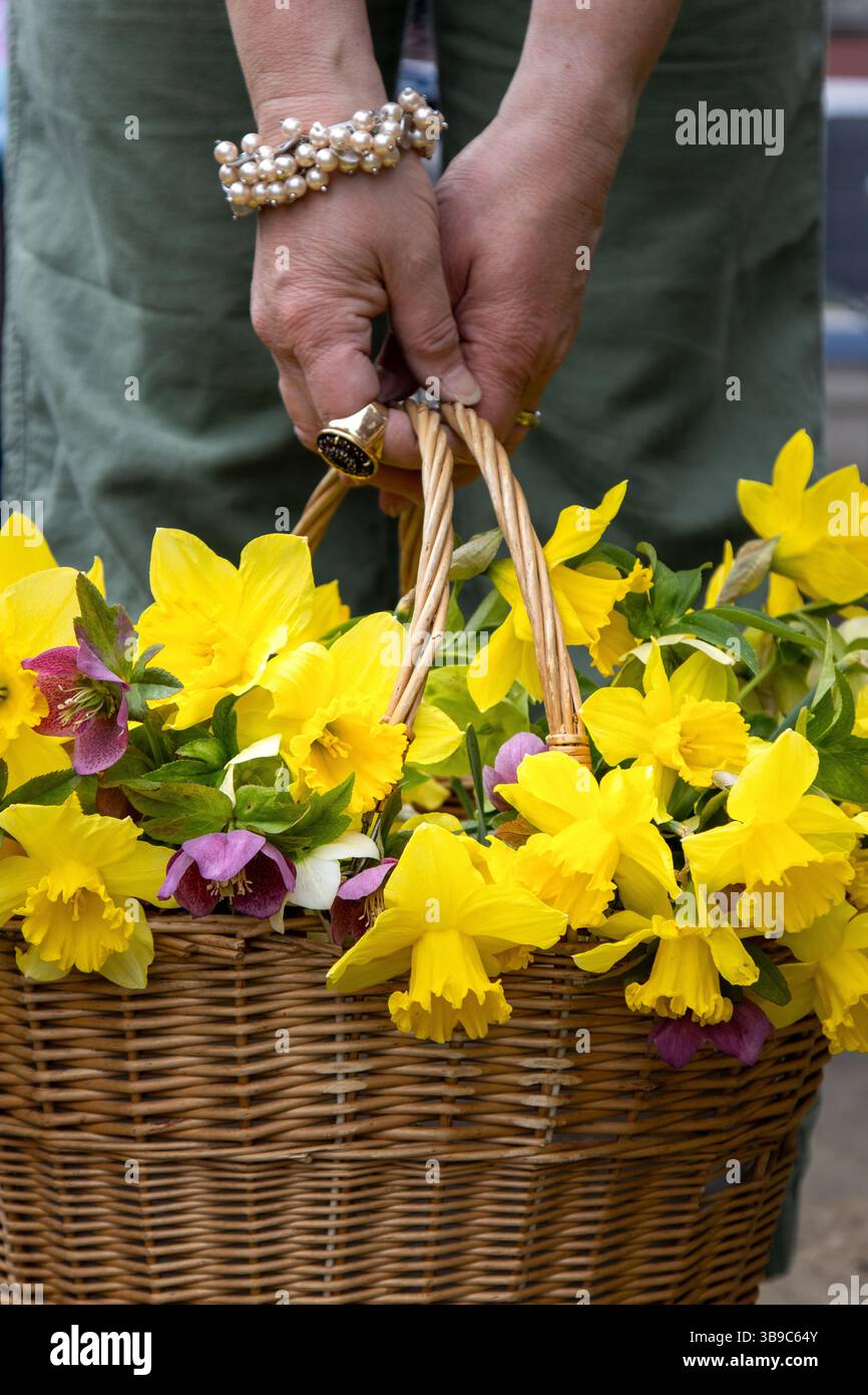 Marcher avec panier de fleurs dans un pantalon en lin vert Banque D'Images