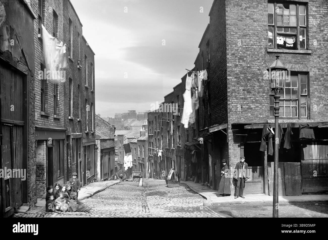 Une photographie de Michael’s Lane à Dublin datant de la fin du XIXe siècle est un rappel brutal des immeubles surpeuplés et insalubres de la ville qui sont devenus des lieux de reproduction pour les maladies infectieuses. Alors que Dublin était aux prises avec les défis de l’urbanisation rapide et de la croissance démographique en plein essor, la situation critique de ceux qui résidaient dans les limites exigues de Michael’s Lane reflétait les préoccupations sociales et de santé publique plus larges de l’époque. Banque D'Images