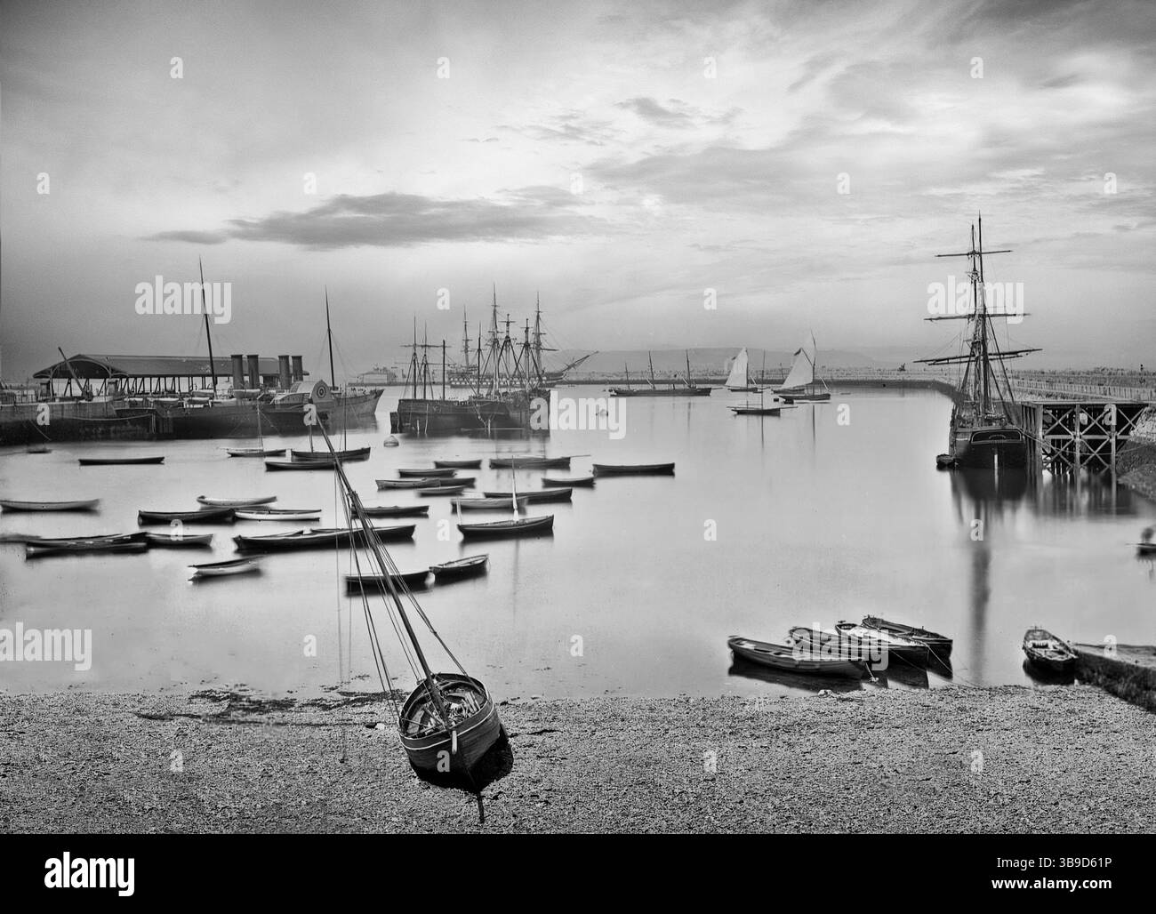 Photographie de la fin du XIXe siècle d'un port tranquille de Dún Laoghaire dans le comté de Dublin, en Irlande, abritant une gamme de voiliers allant d'un clipper aux yachts en passant par un bateau à aubes. Banque D'Images