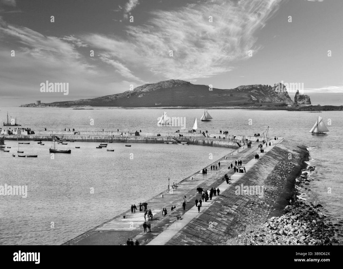 Photographie de la fin du XIXe siècle d'une régate dans la baie de Dublin observée par des spectateurs bordant le mur du port de Howth avec l'œil d'Irlande en arrière-plan. Banque D'Images