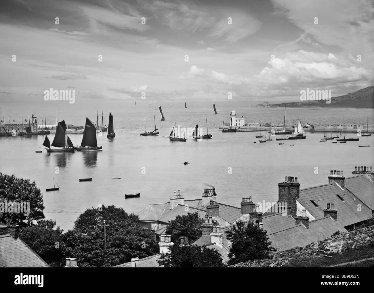 Une photographie de la fin du XIXe siècle représentant des odeurs de pêche en bois à voile au départ du port de Howth pour une nuit de pêche dans la baie de Dublin et la mer d'Irlande. Banque D'Images