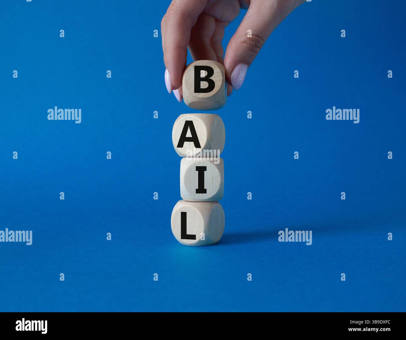 Symbole de béquille. Concept mot bail sur cubes en bois. Main d'homme d'affaires. Beau fond bleu. Business and bail concept. Copier l'espace. Banque D'Images