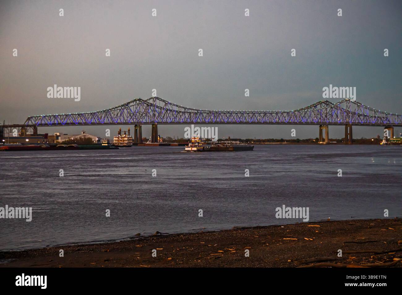 Nouvelle-Orléans, Louisiane - Une péniche passe sous les ponts jumeaux Crescent City Connection. Les ponts transportent l'US Highway 90 à travers le fleuve Mississippi Banque D'Images