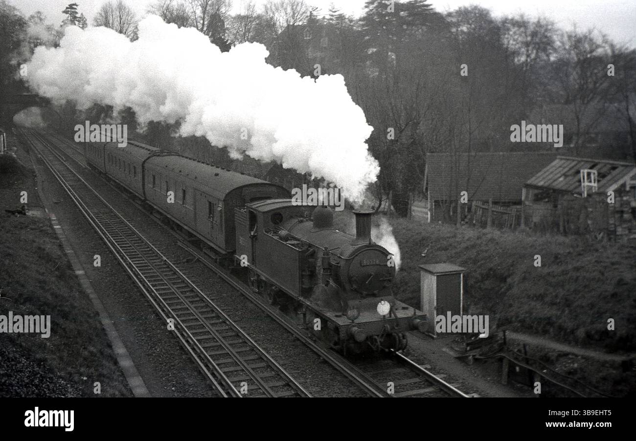 Années 1950, historique, vapeur coulant du moteur d'une locomotive à vapeur sur la voie ferrée, No 30378, Angleterre, Royaume-Uni. Banque D'Images