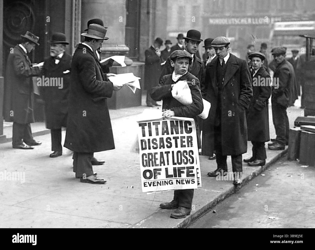 16 avril 1912 : le journal Boy Ned Parfett vend des copies du journal Evening News racontant la catastrophe maritime du Titanic, devant les bureaux de la White Star Line à Oceanic House dans Cockspur Street à Londres. Six ans plus tard, Parfett fut tué lors d'un bombardement allemand alors qu'il servait en France, quelques jours avant la fin de la première Guerre mondiale Banque D'Images