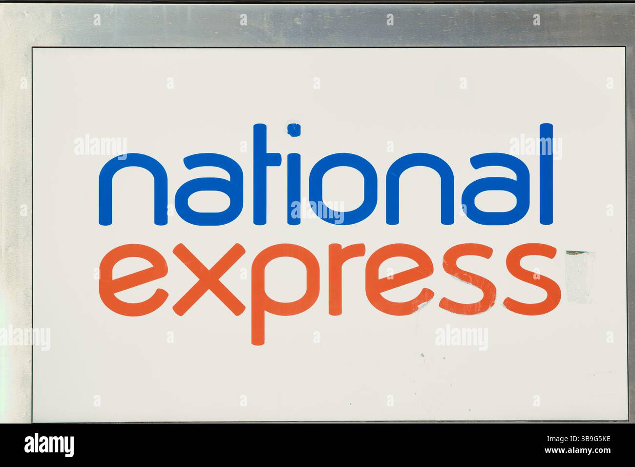 Image du logo « National Express » en bleu et orange sur un panneau blanc, encadré en métal argenté. Banque D'Images