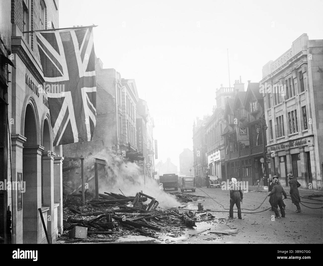 Le drapeau de l'Union est suspendu avec défiance à un bâtiment à la suite du raid aérien qui a dévasté le centre de Coventry dans la nuit du 14/15 novembre 1940. Banque D'Images Le drapeau de l'Union est suspendu avec défiance à un bâtiment à la suite du raid aérien qui a dévasté le centre de Coventry dans la nuit du 14/15 novembre 1940. Banque D'Images