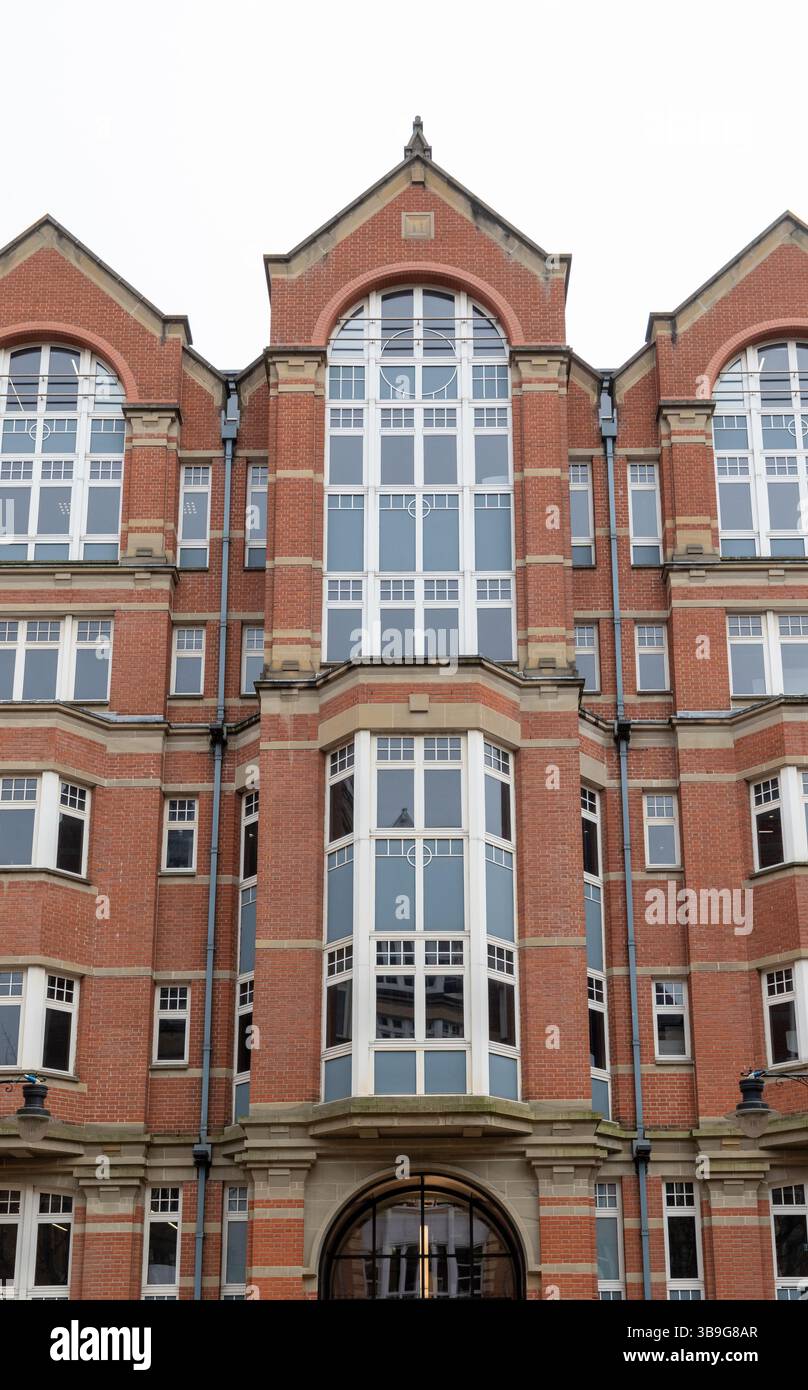 Façade de bâtiment en briques rouges avec plusieurs fenêtres et détails architecturaux voûtés à Leeds, Royaume-Uni. Banque D'Images