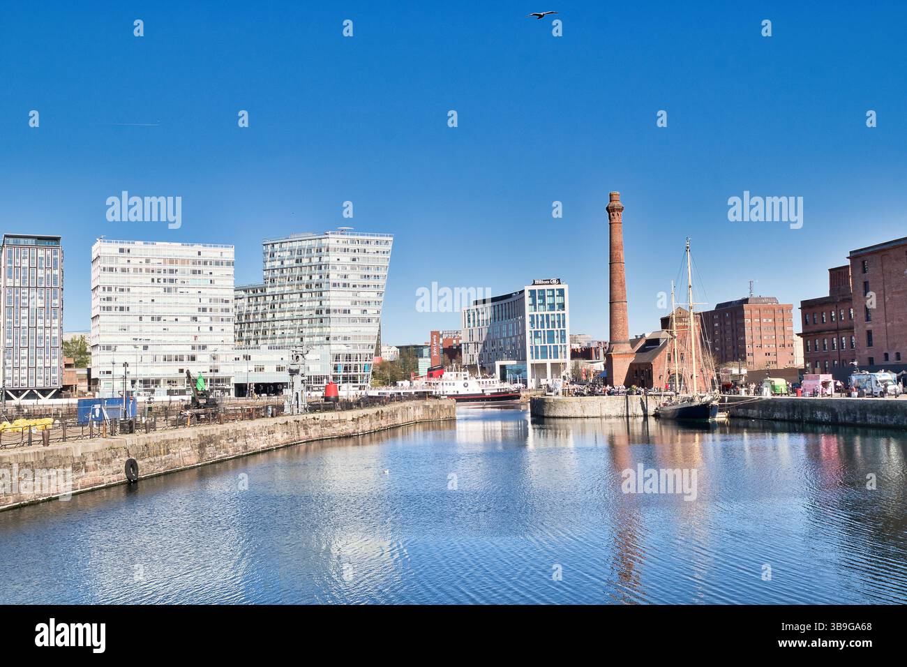 Vue sur le front de mer avec une architecture moderne et historique sous un ciel bleu clair avec un oiseau en vol à Liverpool, Royaume-Uni. Banque D'Images