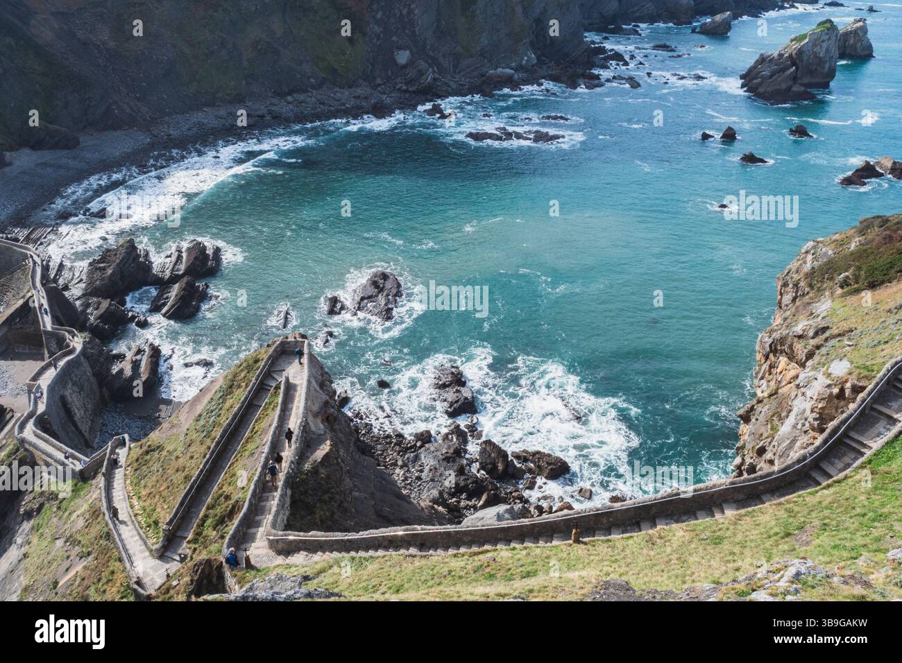 Vue imprenable d'en haut d'un chemin sinueux menant à l'îlot Gaztelugatxe, situé au milieu de la côte rocheuse de Bermeo dans le pays Basque, en Espagne. Banque D'Images