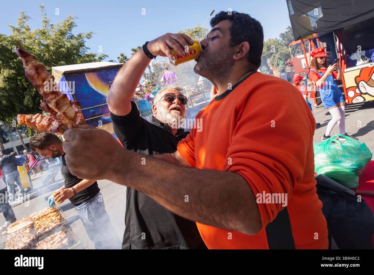 Chypre, Limassol (Lemesos), Grand Carnaval Parade qui a lieu chaque année en mars, Street Food Vendor buvant de la bière Banque D'Images