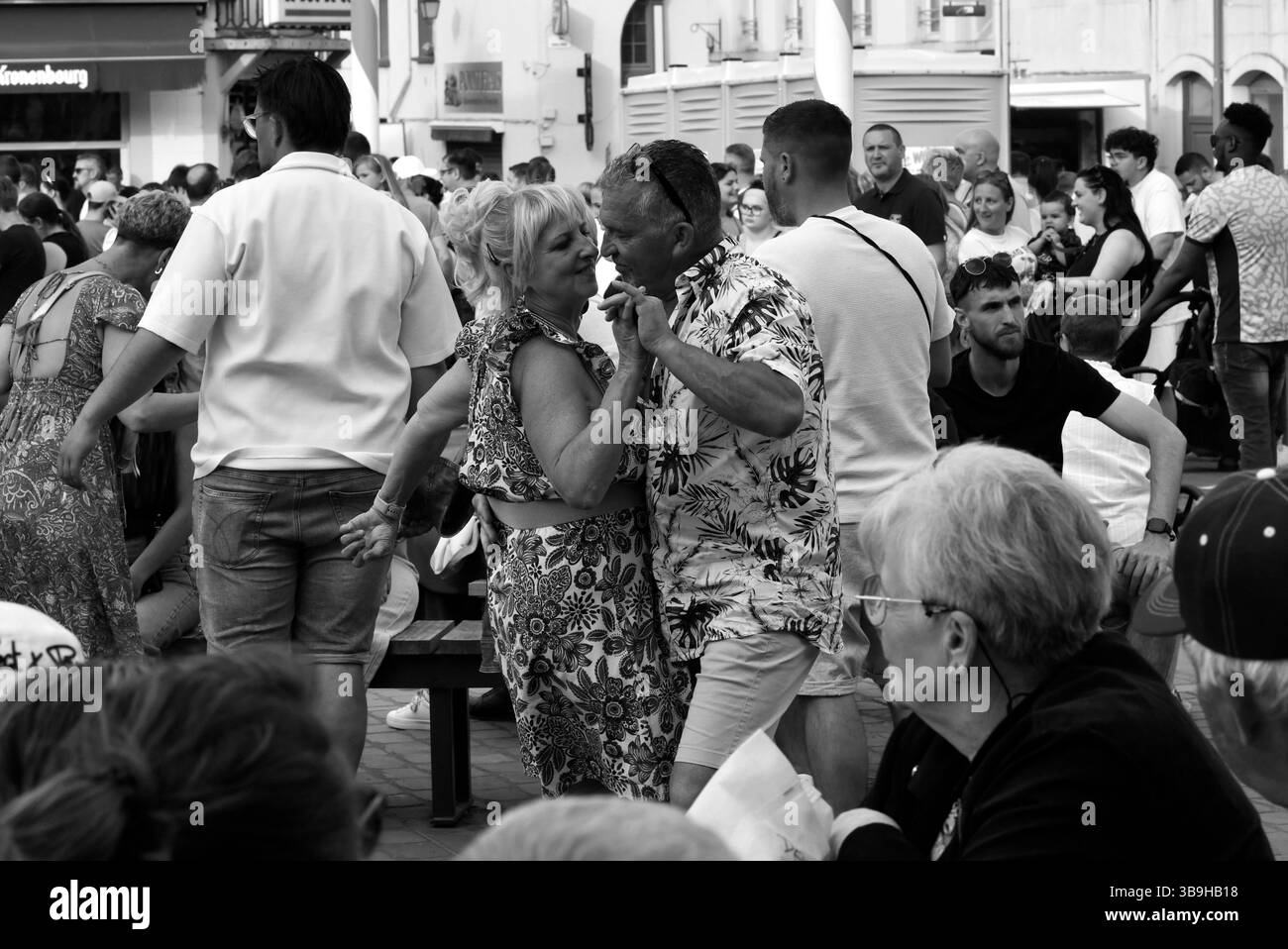 Couples dansant dans la rue pendant le jour de mai célébrations de la Fête du Muguet (jour de la Lilly de la Vallée) le jour de la fête du travail à Guines dans le nord de la France 2025 Banque D'Images
