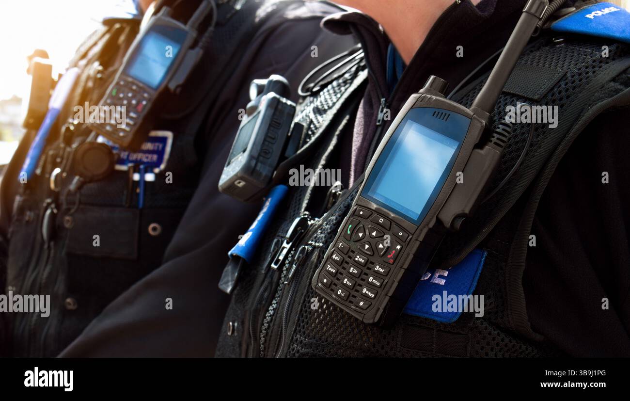 Agents de police – gros plan des agents de police du commissariat portant un gilet résistant aux coups de poignard porté par un couple de policiers du département sur les lieux d'un incident. Banque D'Images