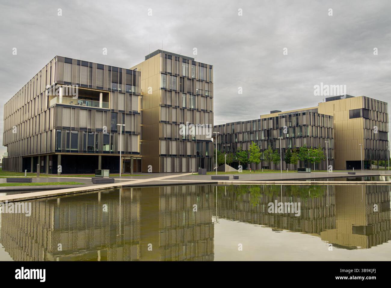 Immeubles de bureaux modernes de ThyssenKrupp reflétant dans l'eau calme avec ciel nuageux à Essen, Allemagne Banque D'Images