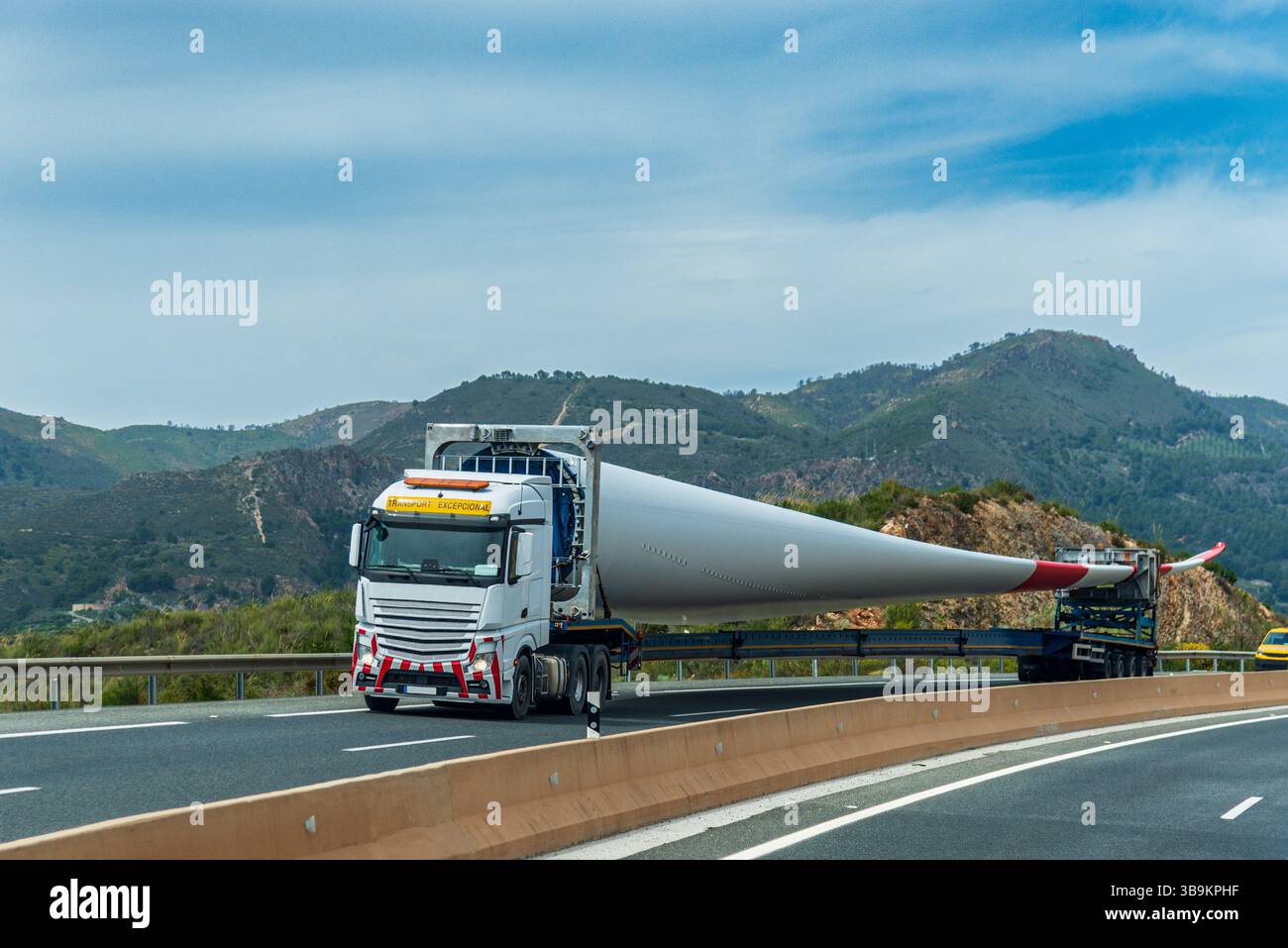 Camion pour transport surdimensionné ou spécial portant une pale d'éolienne, roulant sur une route. Banque D'Images