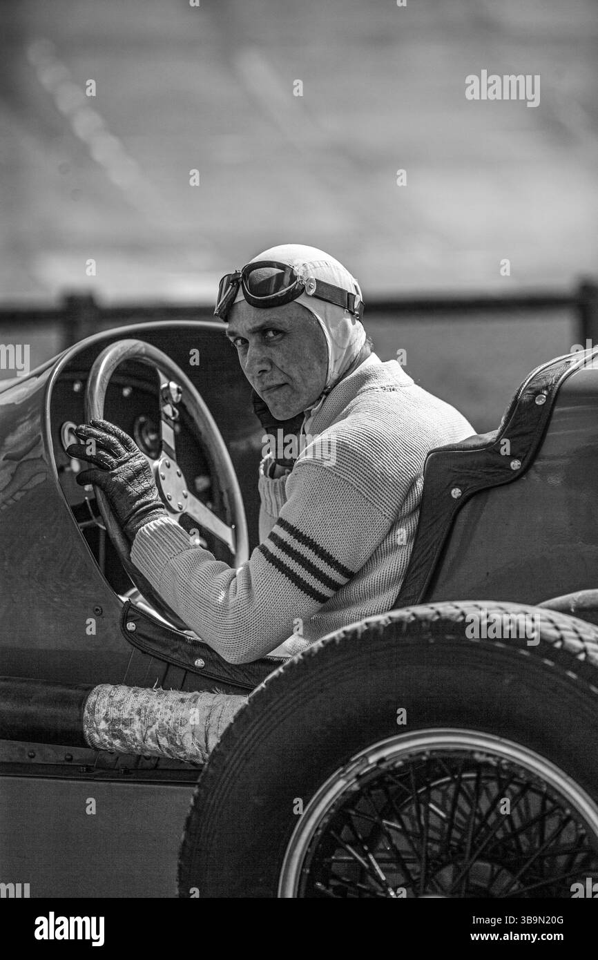 Pilote historique dans le style des années 1930 casque et lunettes pilotant une Graham 8 Lucenti suralimentée de 1932. Banque D'Images