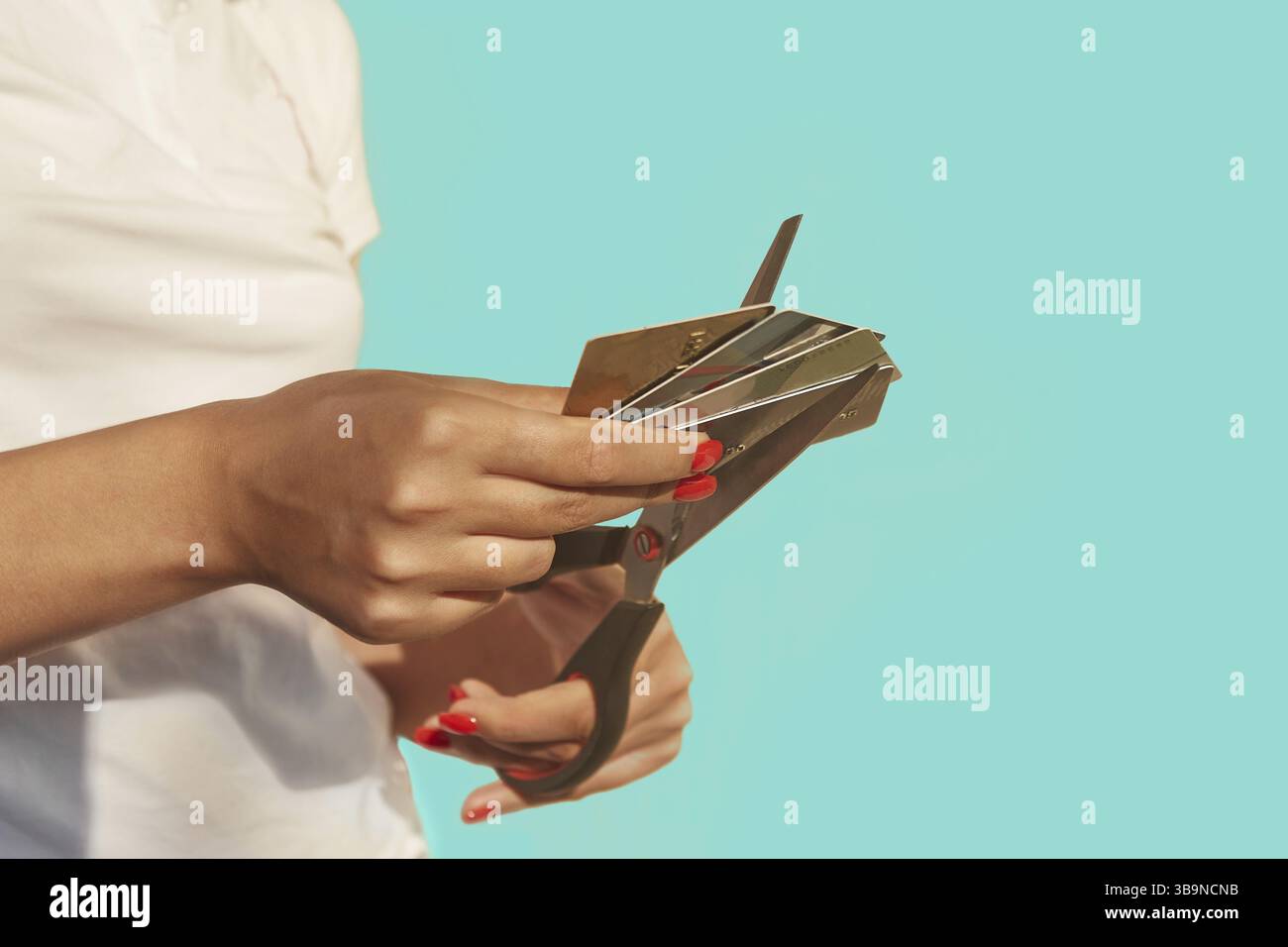 Les mains féminines coupent une pile de cartes de crédit avec des ciseaux. Image à mise au point sélective. Le concept de se débarrasser des prêts, refuser d'utiliser des cartes, shopaholism Banque D'Images